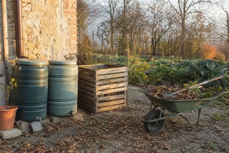 Cisterna di recupero dell'acqua piovana e cumulo di compost in un'azienda agricola di valle (immagine generata con AI).