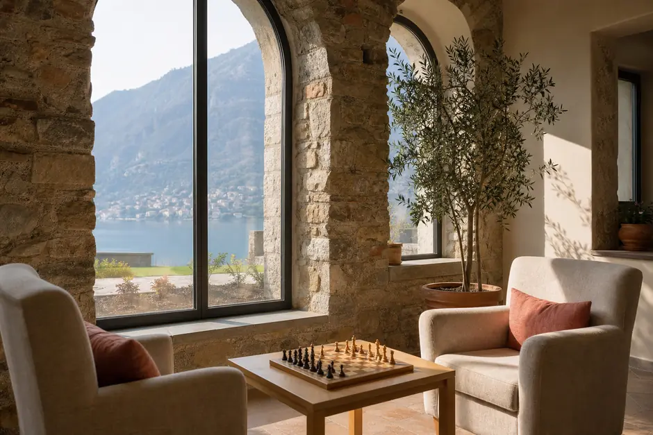 Sala comune di un piccolo centro con due poltrone, tavolino e un ulivo in vaso accanto alle finestre (immagine generata con AI)