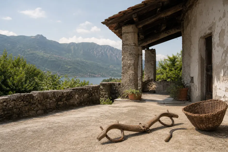 Aia di una vecchia cascina in pietra con un giogo di legno, una falce e un cesto per il grano (immagine generata con AI)